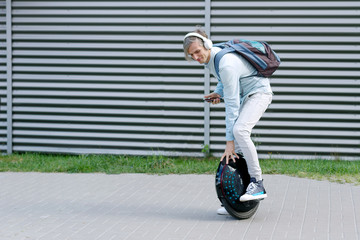Modern young adult male businessman student freelancer riding driving on ecological electric transport futuristic eco electric unicycle scooter, balancing electric wheel. Eco ecology green planet. © Monstar Studio
