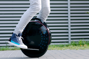Modern young adult male businessman student freelancer riding driving on ecological electric transport futuristic eco electric unicycle scooter, balancing electric wheel. Eco ecology green planet. © Monstar Studio