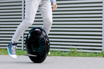 Modern young adult male businessman student freelancer riding driving on ecological electric transport futuristic eco electric unicycle scooter, balancing electric wheel. Eco ecology green planet. © Monstar Studio