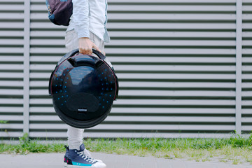 Modern young adult male businessman student freelancer with ecological electric transport futuristic eco electric unicycle scooter, balancing electric wheel. Eco planet, future is now concept. © Monstar Studio