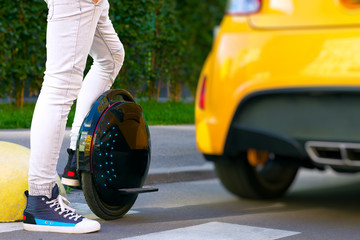 Future is now concept. Ecological transport. Black modern futuristic electric unicycle, unicycle scooter or balancing electric wheel compare with fuel gasoline diesel cars. Eco planet concept © Monstar Studio