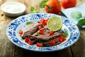 Roast beef appetizer with ripe tomatoes