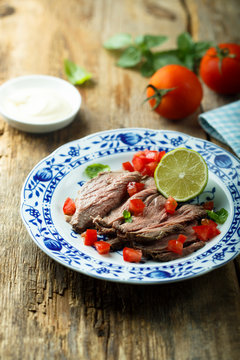Roast beef appetizer with ripe tomatoes