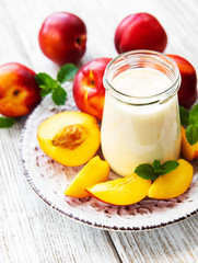 Yogurt with fresh nectarines on a white wooden table