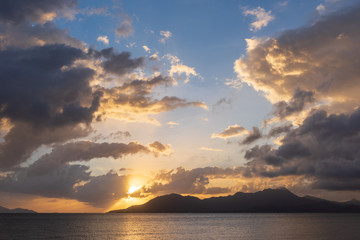 Obraz na płótnie Canvas Sunrise or sunset over water and mountain