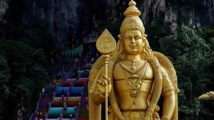 Golden statue of Lord Murugan and colorful stairs of Batu Caves, Malaysia