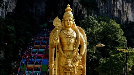Golden statue of Lord Murugan and colorful stairs of Batu Caves, Malaysia