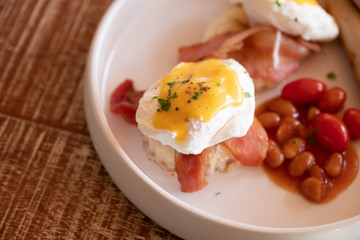 Delicious breakfast with eggs Benedict, sausage, peanut and tomato. English Breakfast.