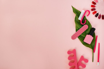 flat lay of manicure and pedicure tools on pink table