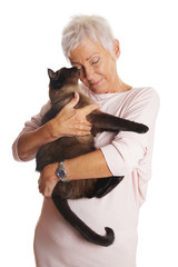 happy mature woman holding siamese cat in her arms. isolated on white.
