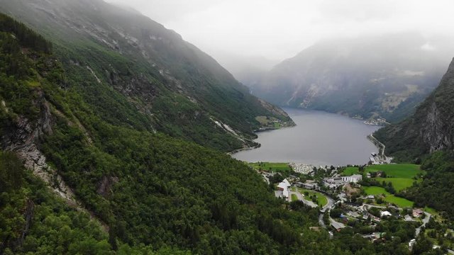 Geiranger village and fjord Geirangerfjord from Flydalsjuvet viewpoint, Norway. Evening time, overcast hazy weather. Travel destination