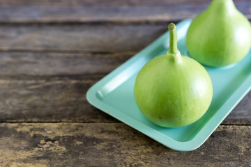 Calabash on green dish with wood background.