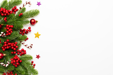 Christmas and New Year's composition. Top view of spruce branches, pine cones, red berries and bell...