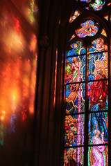 Raggi di sole si riflettono attraverso la vetrata, in stile gotico e decorata con motivi religiosi...