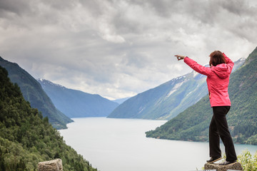 Fototapeta na wymiar Woman tourist in norwegian mountains fjords