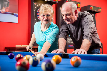 Portrait of a smiling mature couple playing billiard