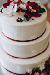 wedding cake with decorated with red and white orchid petals