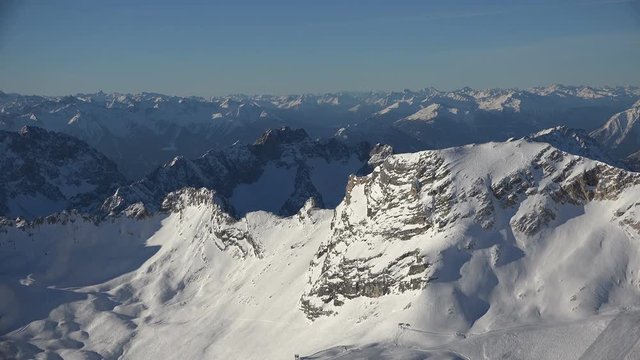 The alpine panorama seen from the summit of Germany's tallest mountain, the Zugspitze, looking southwest including the skiing resort on the Zugspitz glaciers, shot on a beautiful winter's day.
