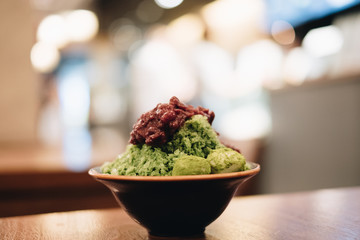 Closeup green tea Bingsu ( or Bingsoo) on tray,Korean shaved ice dessert with sweet toppings with varieties with ingredients, popular dessert.