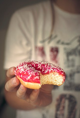 Fresh donut in her hand