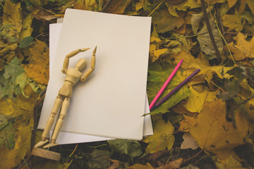 White paper with pencil and dummy for drawing on the autumn leaves. Background with copy space.