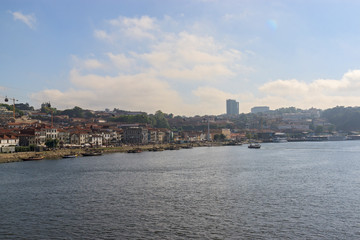 City view of Vila Nova de Gaia from the river Douro. Porto, Portugal. Boats near the shore.