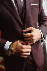 man in a red suit with watches on his arm