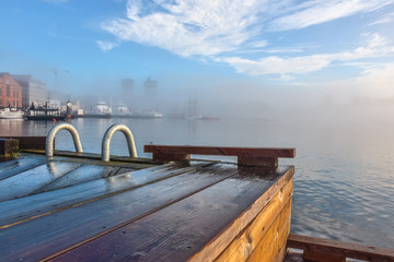 Wooden pier, morning mist, view of Oslo, Norway