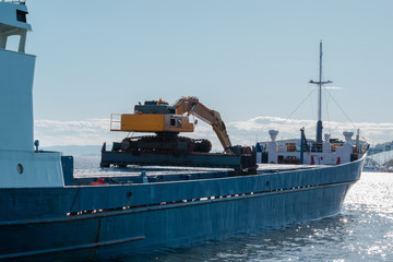 Cargo ship. Large container vessel unloaded. Excavator on a ship. Oslo, Norway