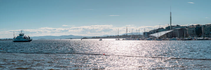 Boats on the sea. Panoramic view to the sea. Sunny day, scandinavian nature. Stunning landscape. The sun is reflected in the water. Oslo, Norway