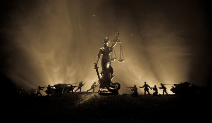 War - no justice concept. Military silhouettes fighting scene and The Statue of Justice on a dark...