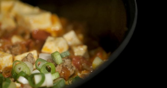Asian chef cooking Chinese style Sichuan mapo tofu food in a hot pan