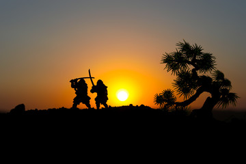 Silhouette of two samurais in duel. Picture with two samurais and sunset sky. Selective focus