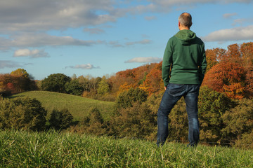 Naklejka na ściany i meble Mann genießt den Blick auf die schöne Herbst Landschaft bei Plön