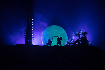 Samurai fighting concept. Silhouette of samurais in duel near tree and old temple. Picture with two...
