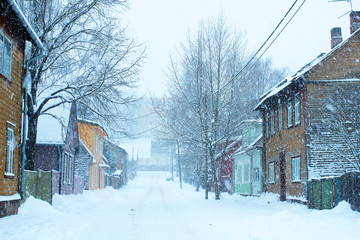 snowy winter scene in town. snowfall in a small street with colorful wooden houses