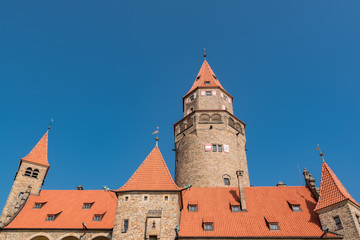 Romantic Medieval Castle "Bouzov", Czech Republic and a background of the blue sky. The orange roof and blue sky makes nice contrast. Located in the South Moravia region. Europe. Tourism in Europe.