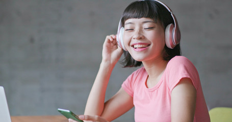 Woman enjoy music on cellphone and listen to headphone