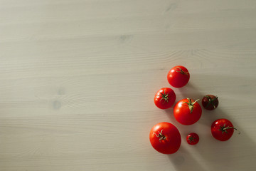 fresh organic home grown tomatoes on light wooden table with copy space