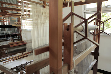 Close up ancient weaving loom in an interior of a modern building