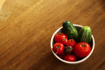 top view of fresh organic home grown vegetables on a brown wooden table. tomatoes, cucumbers and peas
