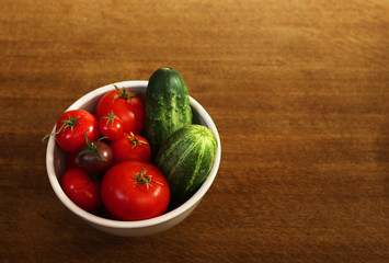 top view of fresh organic home grown vegetables on a brown wooden table. tomatoes, cucumbers and peas