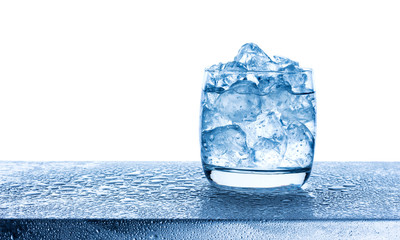 Water with crushed ice cubes in glass on white background