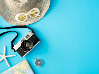 top view travel concept with retro camera films and Outfit of traveler on blue background with copy space, Tourist essentials, vintage tone effect