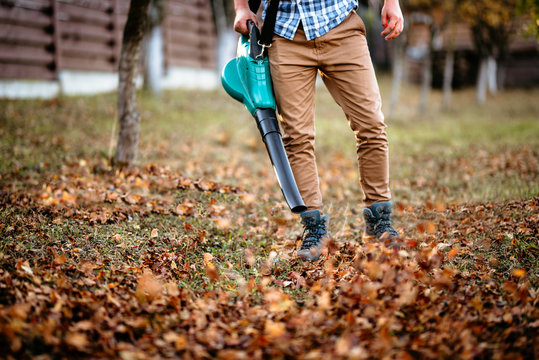 professional worker, man using leaf blower for autumn cleaning