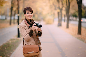 portrait female photographer on background of autumn city