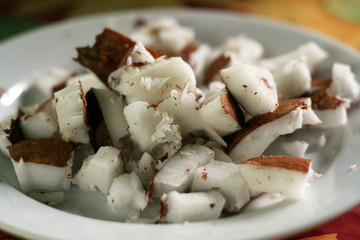 close up of chopped pieces of coconut on a white plate