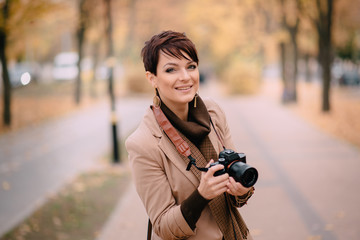 portrait female photographer on background of autumn city