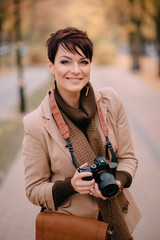 portrait female photographer on background of autumn city
