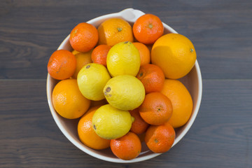 fruit bowl with different citrus fruits, oranges, tangerines and lemons